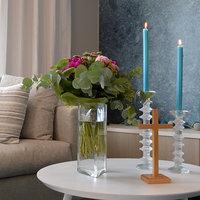 Kodin pöydällä kukkakimppu, kaksi sinistä kynttilää ja risti. Siunaaminen