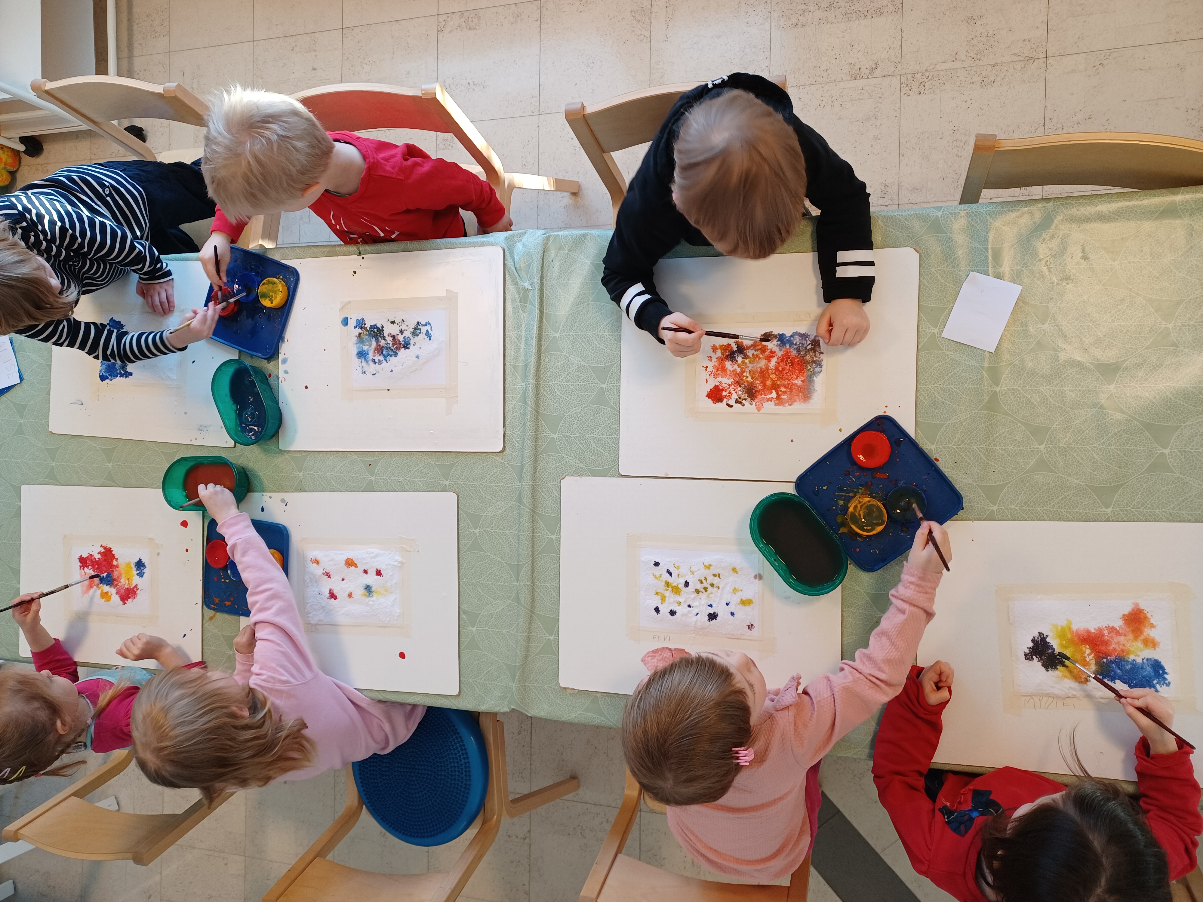 Lapset maalaavat vesiväreillä valkoiselle paperille.